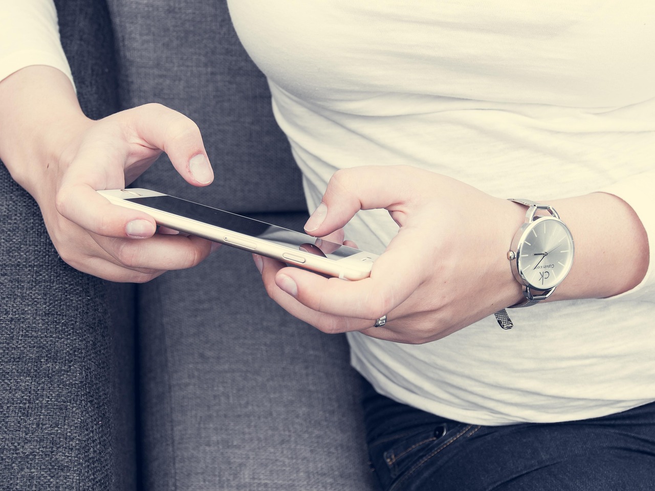 スマートフォンを両手で操作する利用者